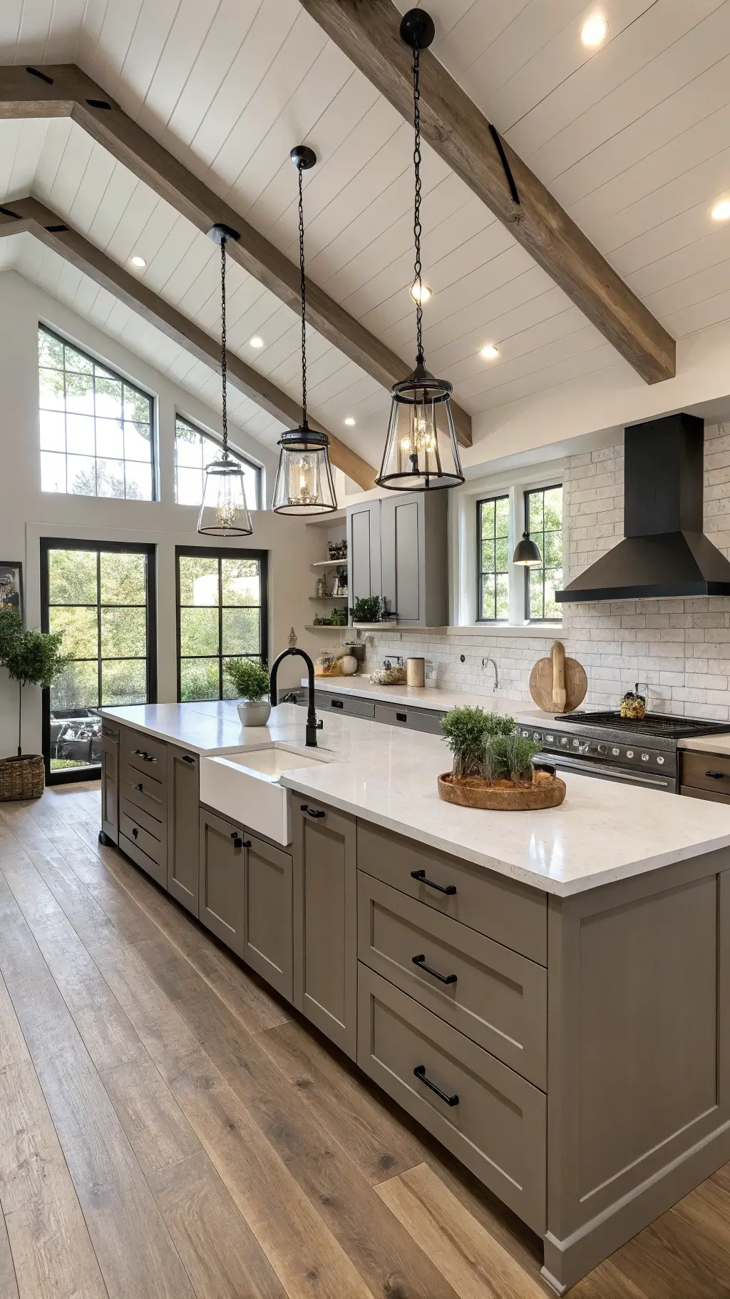 Modern farmhouse kitchen with vaulted ceiling, exposed beams, dark taupe cabinets, white concrete countertops, matte black hardware, and industrial pendant lights.