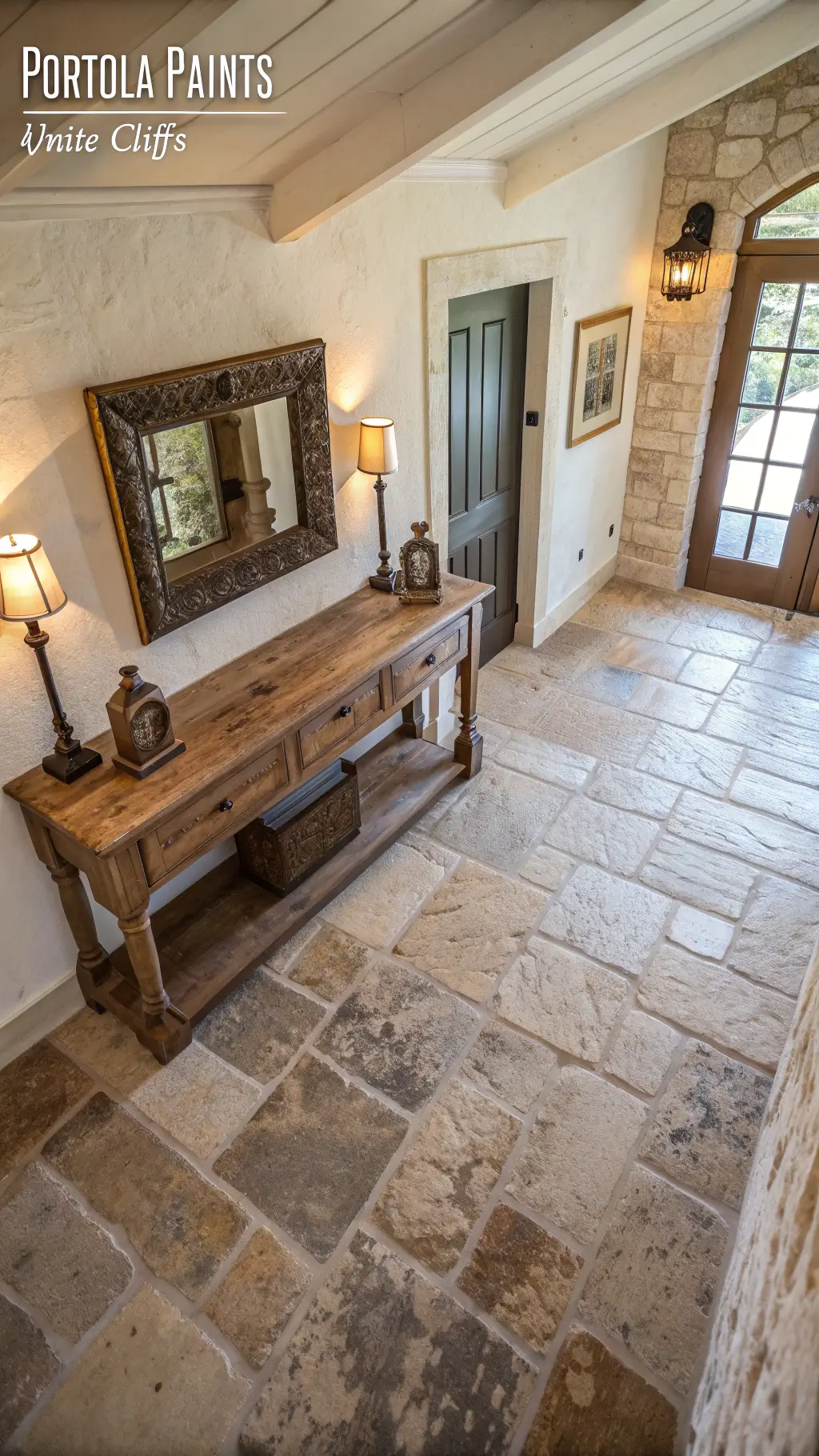 Aerial view of a vintage 6x8ft entryway with reclaimed stone flooring, a wooden console table, hand-forged iron coat hooks, and lime washed walls in Portola Paints 'White Cliffs' shade, beautifully illuminated by afternoon light.